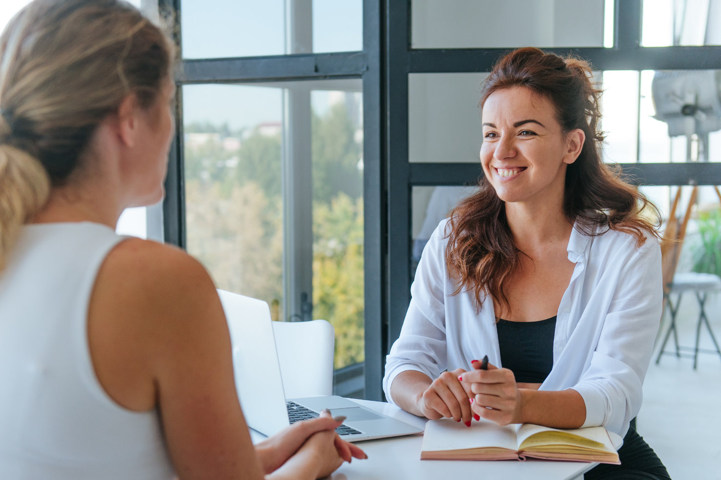 zwei-freuen-sitzen-am-tisch-bei-einer-coaching-sitzung