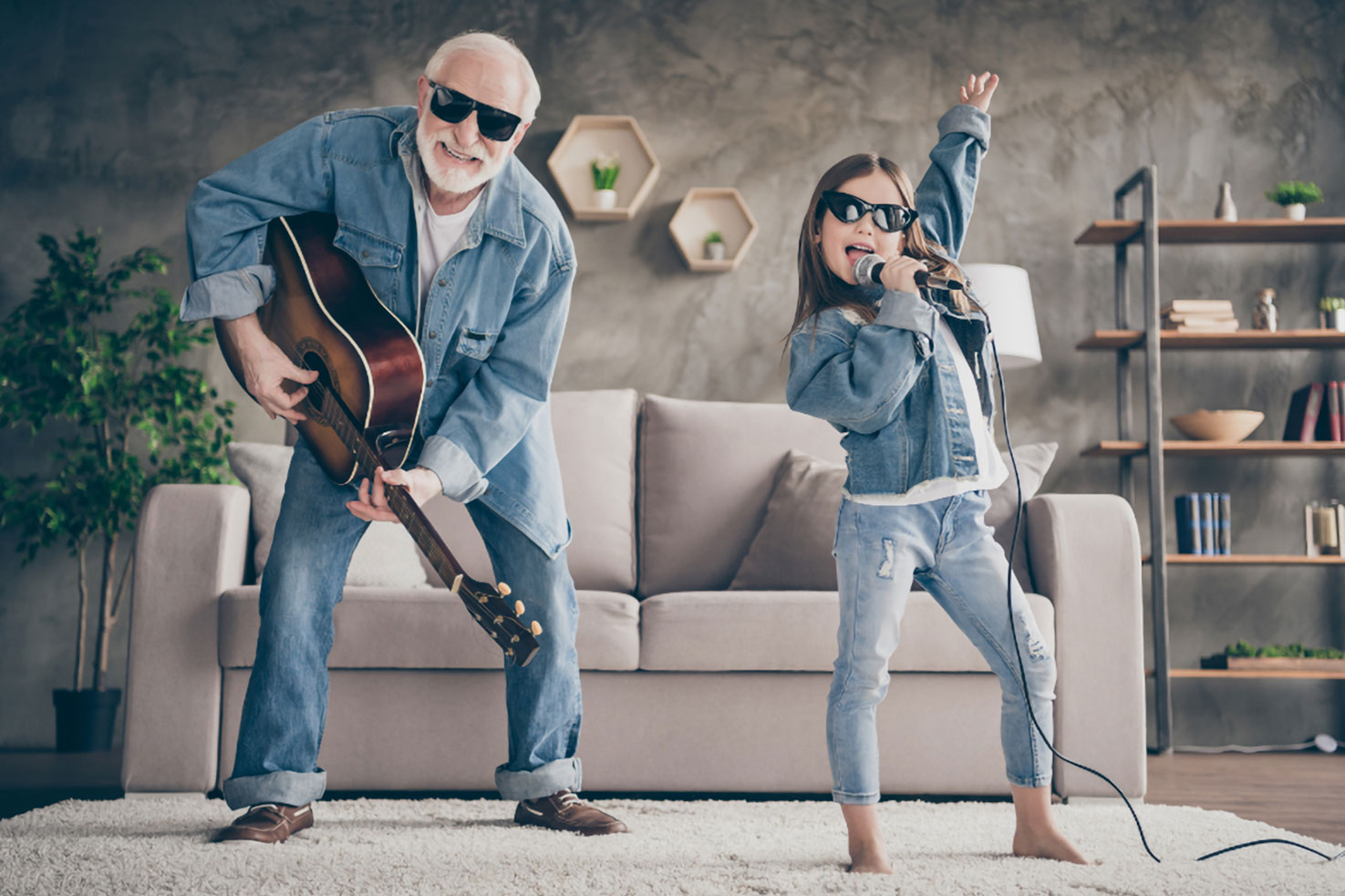 Opa und Enkelin rocken vor dem Sofa. Der Opa hat das für seine Enkelin unwichtige Ziele losgelassen