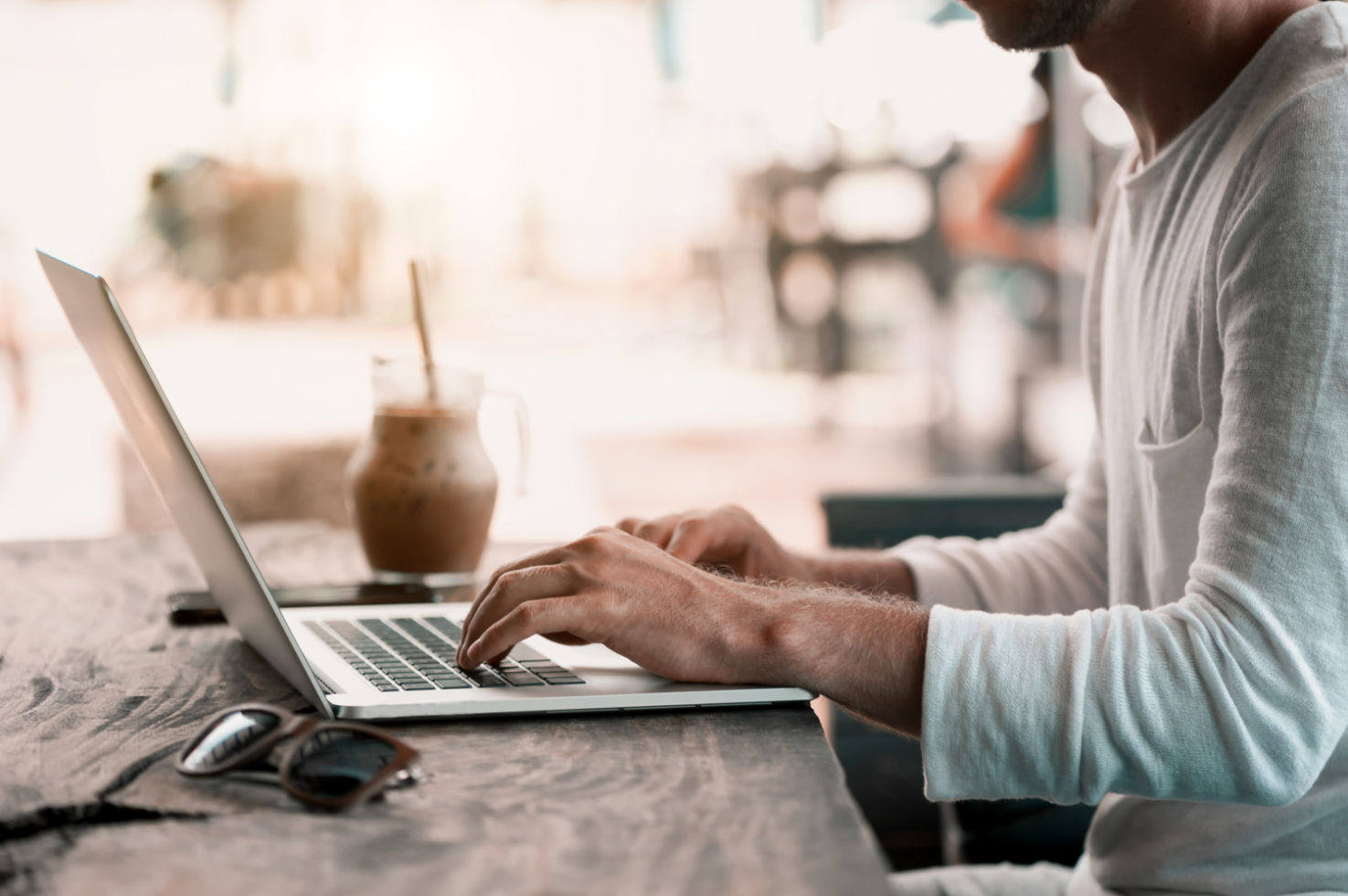 mann_am_tisch_sitz_vor_dem_Laptop_und_schreibt_eine_nachricht_an seinen_coach